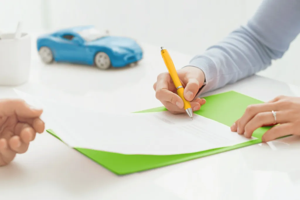 Woman signing paper to remove cosigner from car loan
