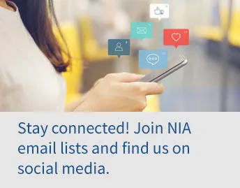 Woman looking at phone with social icons floating above. Text reads, Stay connected! Join NIA email lists and find us on social media