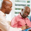 An advisor helps an older man with his legal and financial paperwork